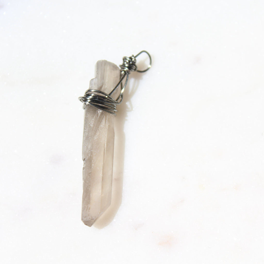 Crystal pendant with silver wire wrapping on a white background