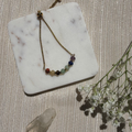 Bracelet with colorful beads on a marble stand with a textured background